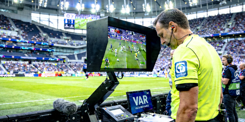 世界杯比赛裁判使用VAR视频助理裁判系统回放检查关键判罚的场景